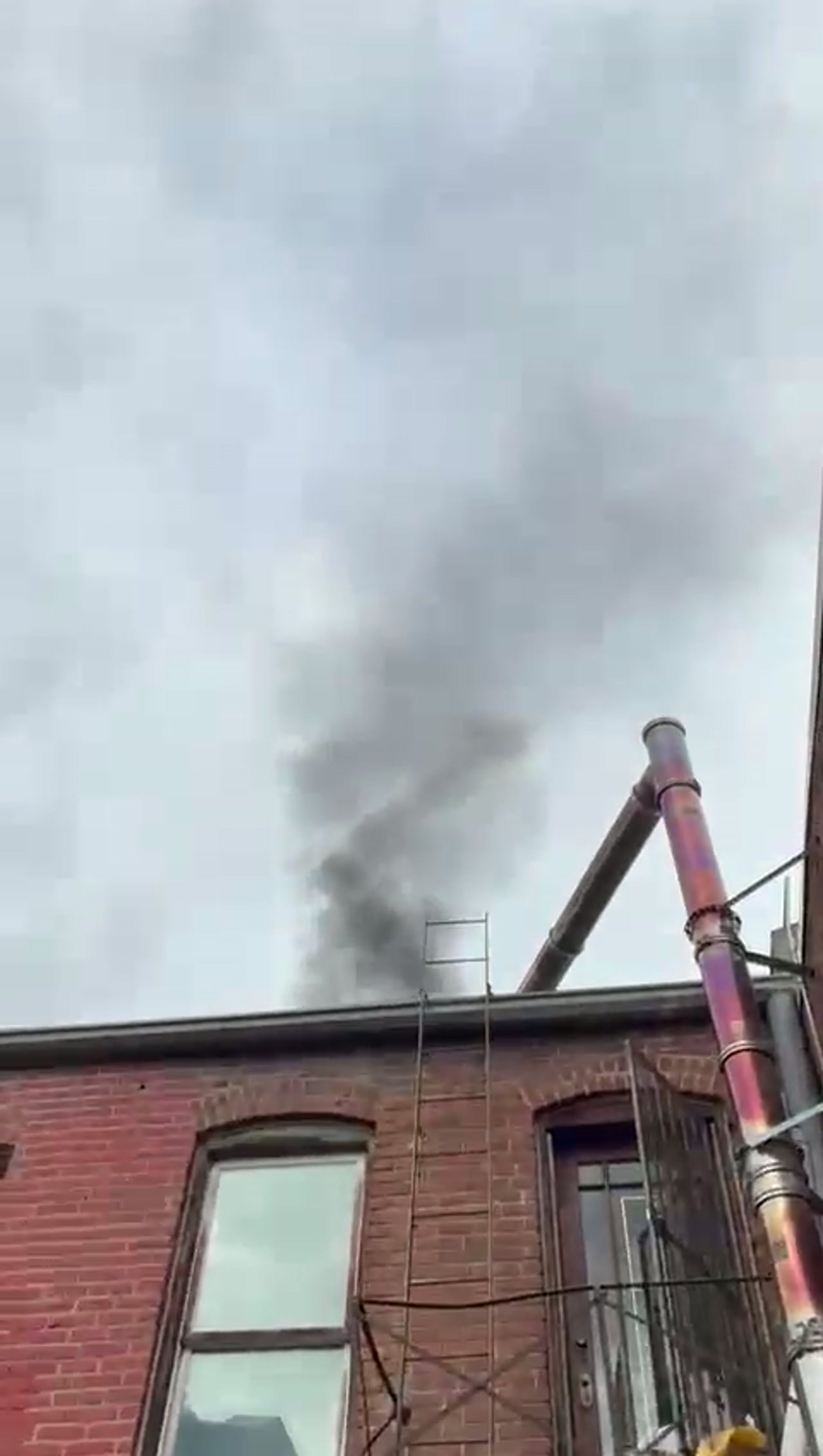 Adam Chimney Sweep starting a smoke test on a Denver brick building chimney